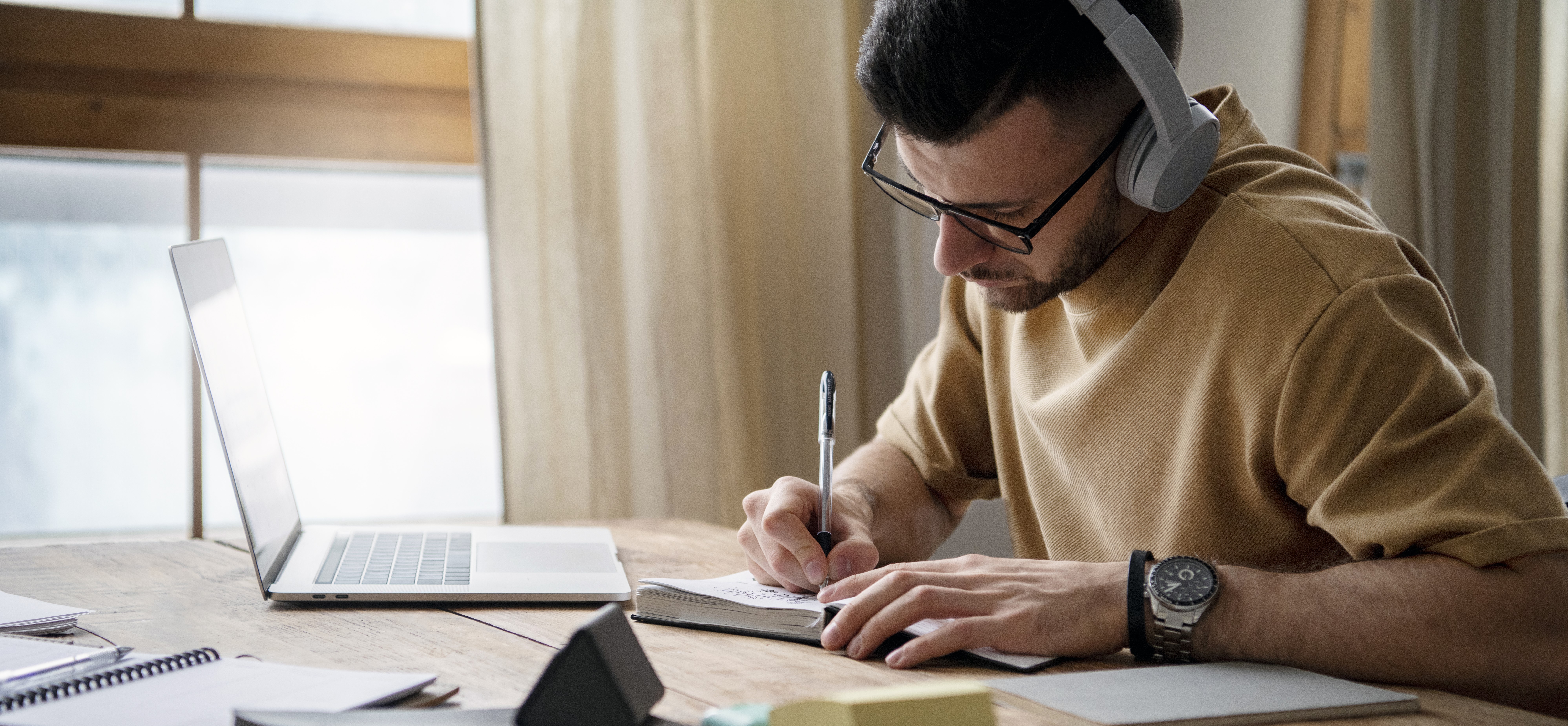 young man writing notebook study session